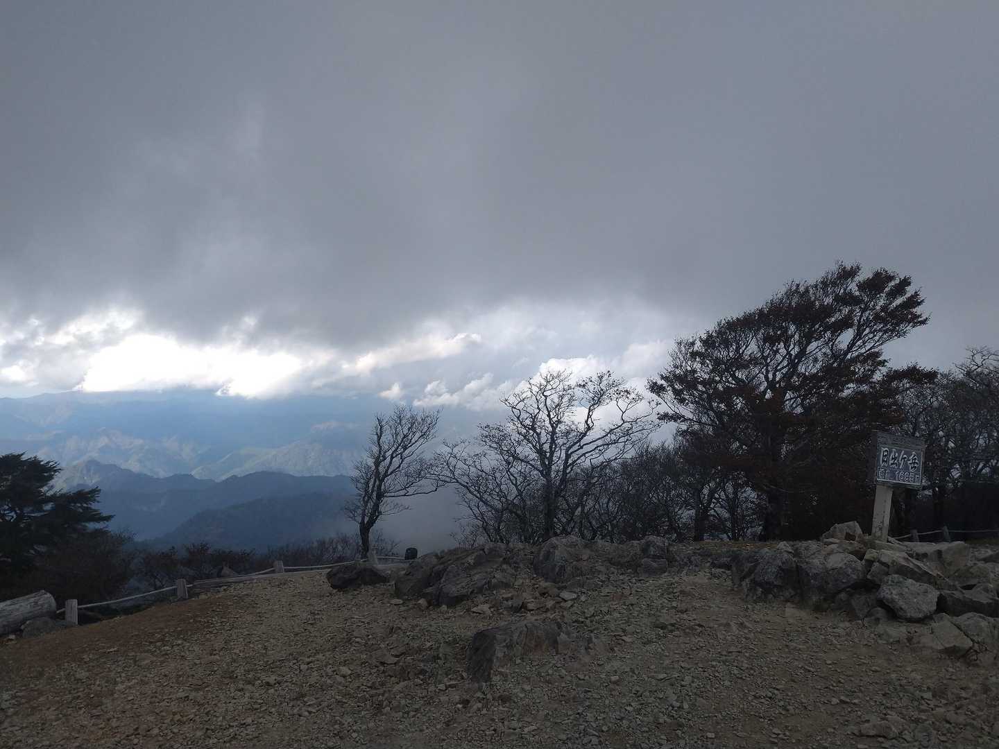 曇り空の下の日出ヶ岳山頂と周囲の山並み